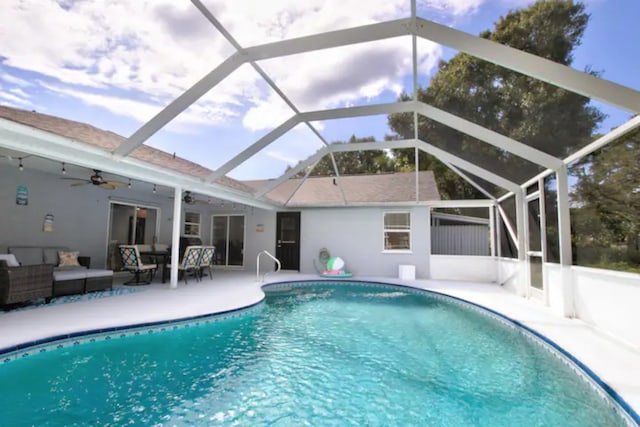 pool with outdoor lounge area, a patio, a lanai, and ceiling fan