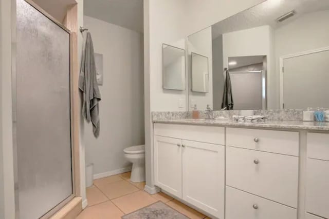 full bathroom featuring vanity, baseboards, a shower stall, tile patterned floors, and toilet