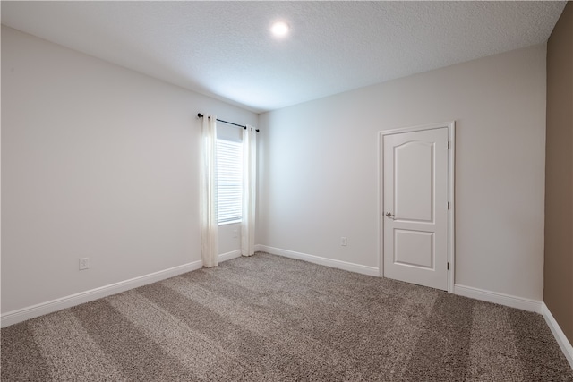 carpeted spare room with a textured ceiling