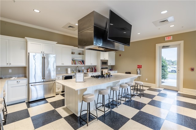 kitchen featuring white cabinetry, a center island, stainless steel appliances, a kitchen breakfast bar, and crown molding