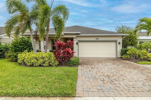 5964 Long Leaf Ln, Vero Beach, FL 32966 - view of front of home with stucco siding, decorative driveway, an attached garage, and a front yard