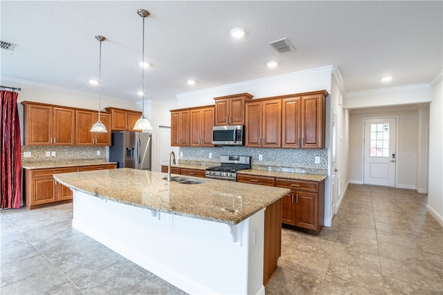 kitchen with a kitchen breakfast bar, sink, an island with sink, decorative light fixtures, and stainless steel appliances