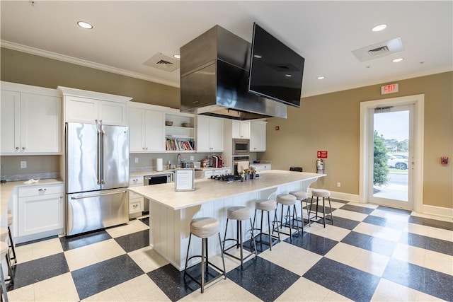 kitchen with white cabinets, a center island, stainless steel appliances, and a breakfast bar area