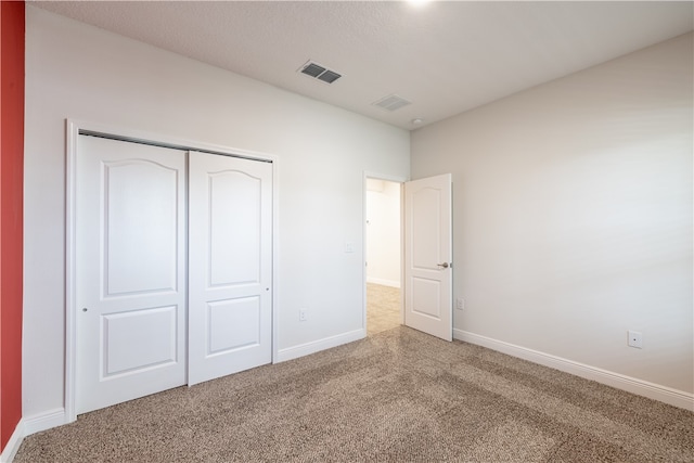 unfurnished bedroom featuring carpet and a closet