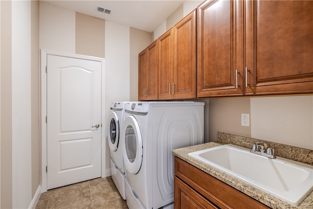 laundry room with cabinets, sink, and washing machine and clothes dryer