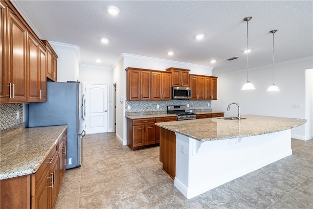 kitchen with stainless steel appliances, light stone counters, hanging light fixtures, and an island with sink