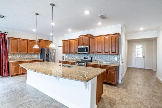 5964 Long Leaf Ln, Vero Beach, FL 32966 - kitchen featuring stainless steel appliances, a sink, brown cabinets, decorative backsplash, and a center island with sink