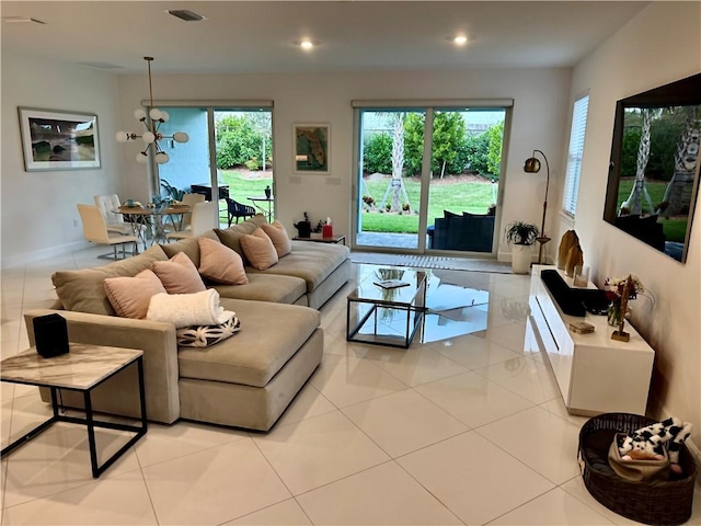 living area featuring a notable chandelier, light tile patterned floors, recessed lighting, visible vents, and baseboards