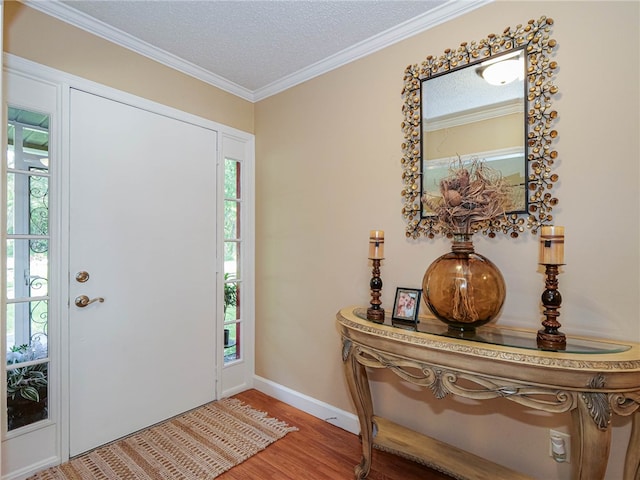 entrance foyer with hardwood / wood-style floors, a textured ceiling, and ornamental molding