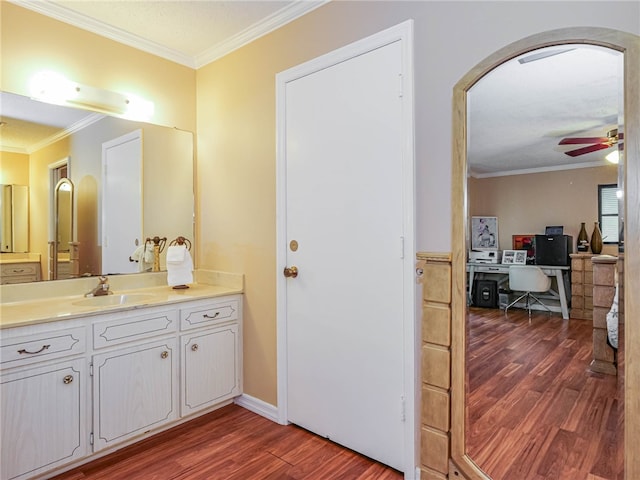 bathroom with vanity, hardwood / wood-style flooring, ceiling fan, and ornamental molding