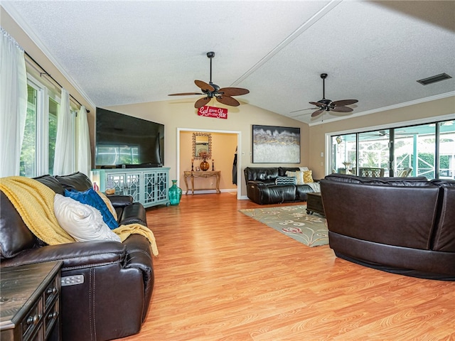 living room with vaulted ceiling, ceiling fan, ornamental molding, a textured ceiling, and light hardwood / wood-style floors