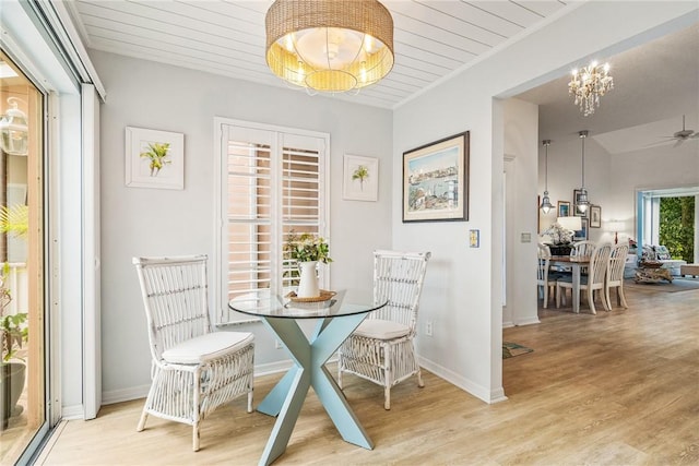 dining space featuring a chandelier, wood ceiling, and light wood-type flooring