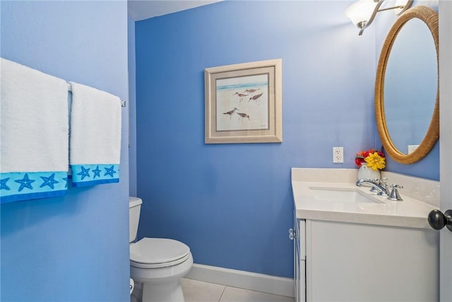 bathroom with toilet, vanity, and tile patterned floors