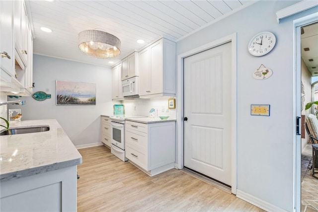 kitchen featuring light stone counters, white cabinets, light hardwood / wood-style floors, and white appliances