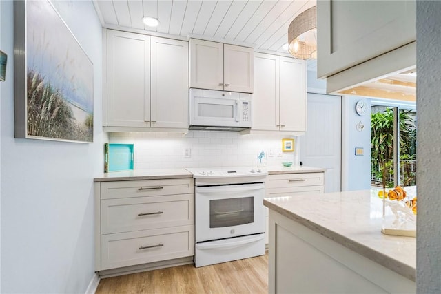 kitchen with light stone counters, backsplash, white appliances, white cabinets, and light wood-type flooring