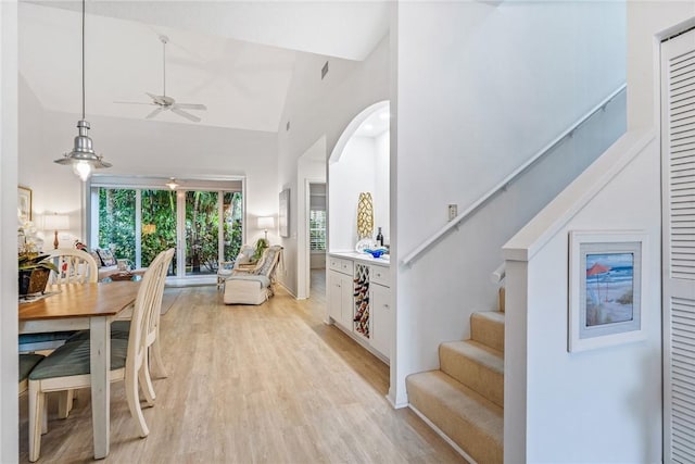 dining room featuring ceiling fan, light hardwood / wood-style flooring, and high vaulted ceiling