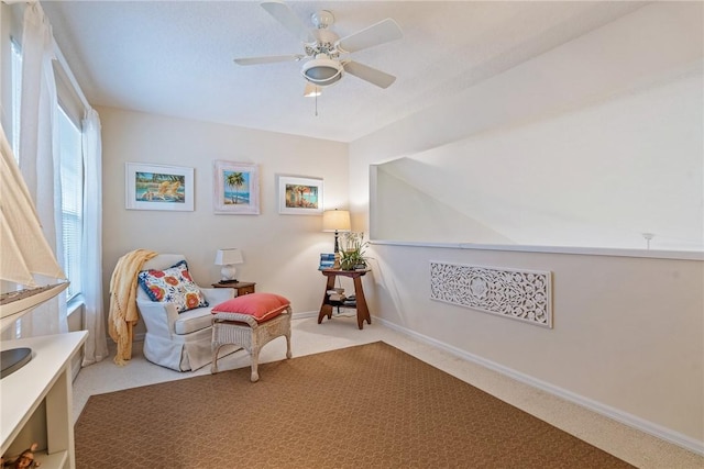 sitting room with ceiling fan and light colored carpet