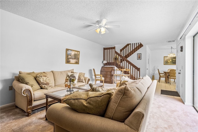 living room with ceiling fan, a textured ceiling, and light colored carpet