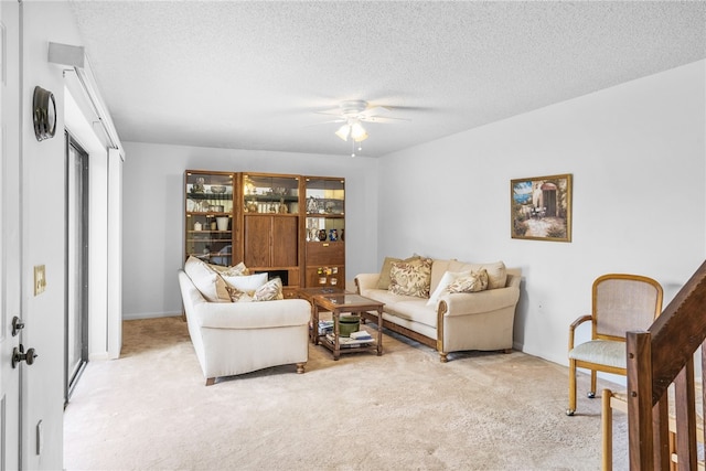 carpeted living room with a textured ceiling and ceiling fan