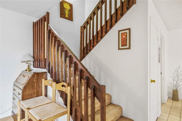 stairway featuring tile patterned flooring and a textured ceiling