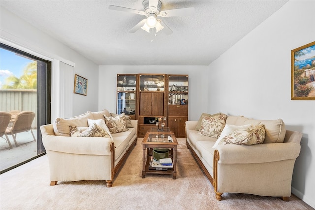 carpeted living room featuring a textured ceiling and ceiling fan