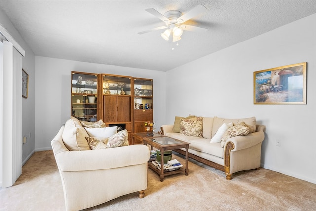 carpeted living room featuring ceiling fan and a textured ceiling