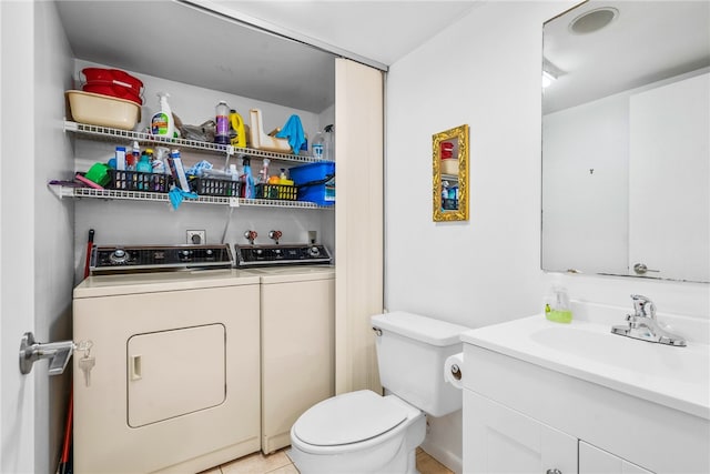 bathroom with toilet, vanity, tile patterned floors, and washer and dryer