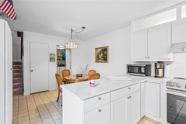 kitchen with stainless steel appliances, white cabinetry, decorative light fixtures, and backsplash