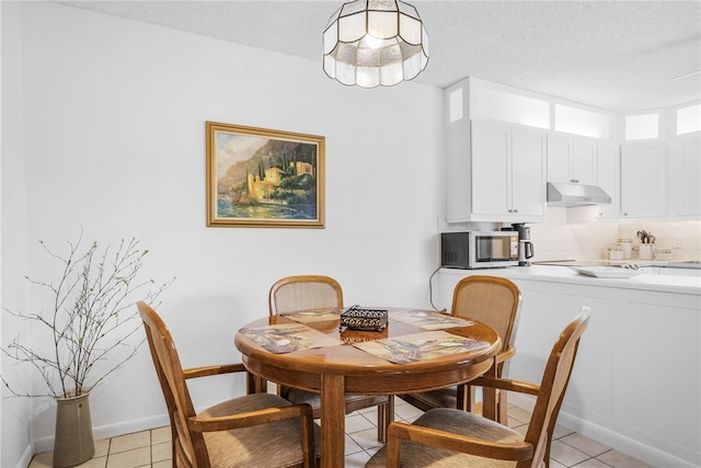 tiled dining room featuring a textured ceiling