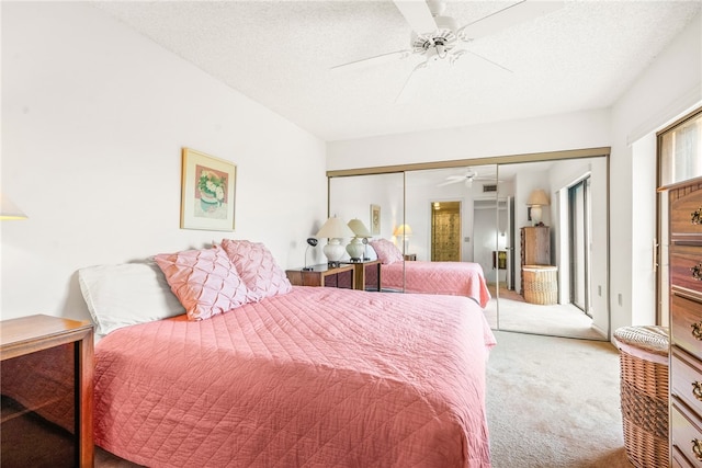 carpeted bedroom featuring a textured ceiling, ceiling fan, and a closet