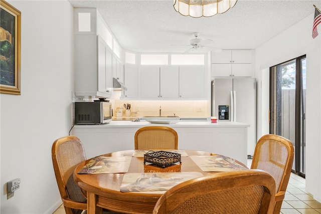 dining room with ceiling fan, a textured ceiling, and light tile patterned floors