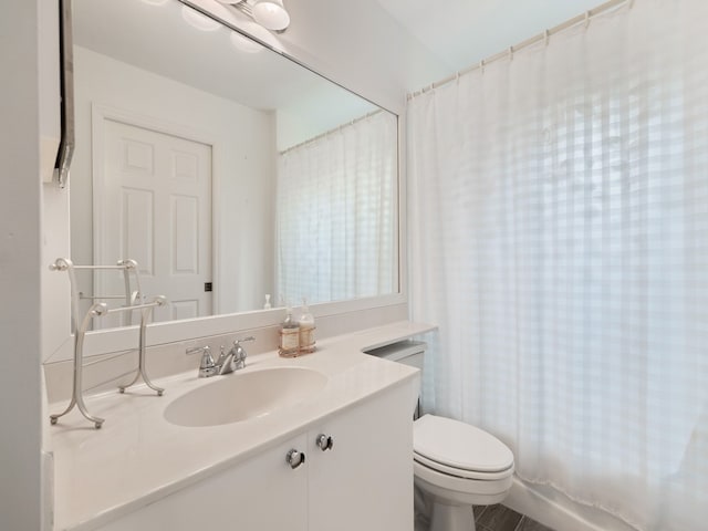 full bathroom featuring shower / bath combo, vanity, and toilet