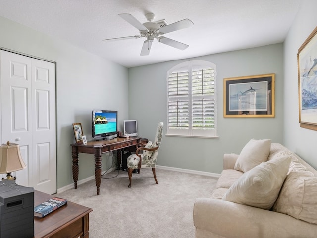 carpeted office space featuring ceiling fan and a textured ceiling