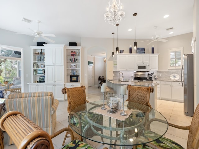 dining room featuring sink, light tile patterned floors, and ceiling fan with notable chandelier