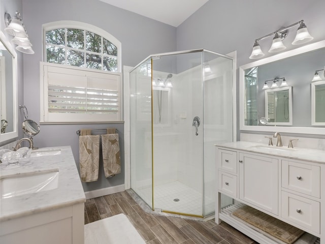 bathroom with hardwood / wood-style floors, vanity, and a shower with shower door