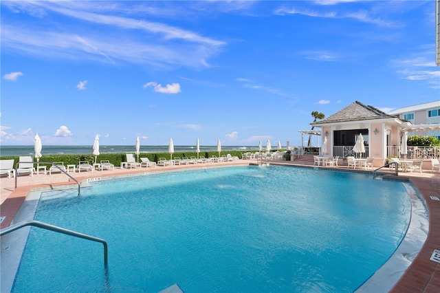 view of swimming pool featuring a patio and a water view