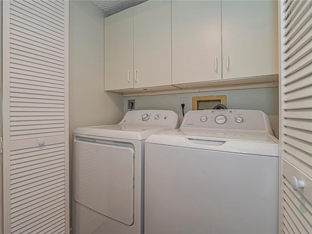 laundry room with cabinet space and washing machine and clothes dryer