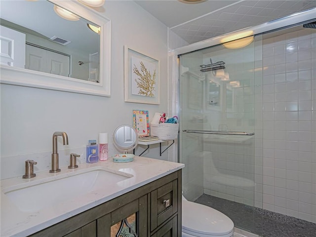 full bath with toilet, a shower stall, visible vents, and vanity