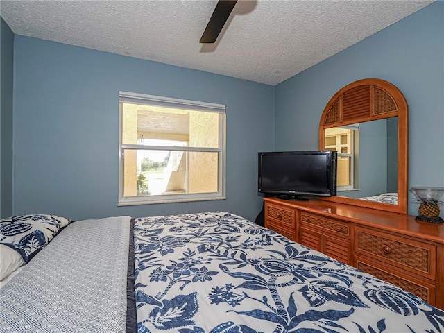 bedroom with ceiling fan and a textured ceiling