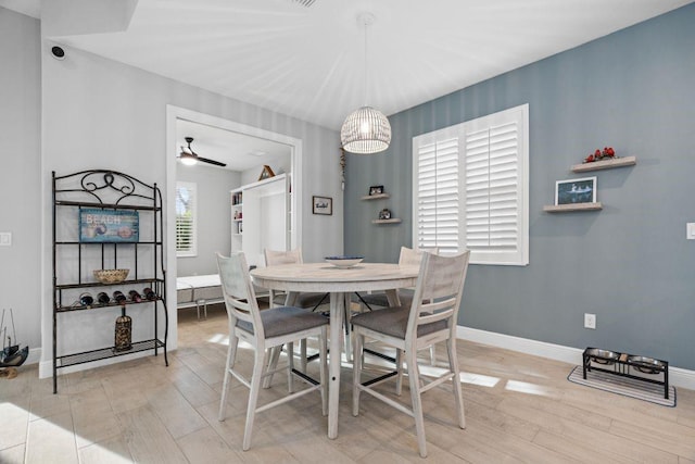 dining room with ceiling fan with notable chandelier and light wood-type flooring