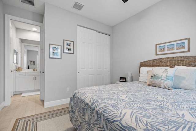 bedroom with light hardwood / wood-style floors, ensuite bathroom, and a closet