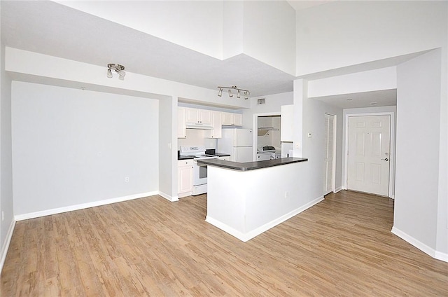 kitchen featuring white appliances, kitchen peninsula, light wood-type flooring, and white cabinets