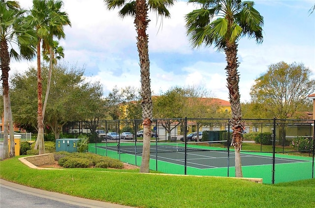 view of tennis court featuring a yard