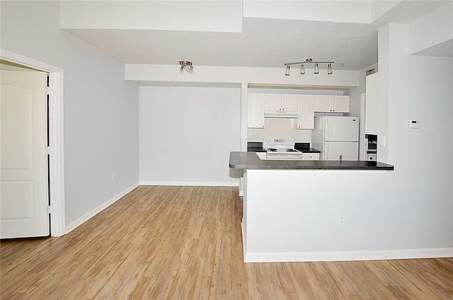 kitchen featuring light wood-type flooring, white cabinets, white appliances, and kitchen peninsula