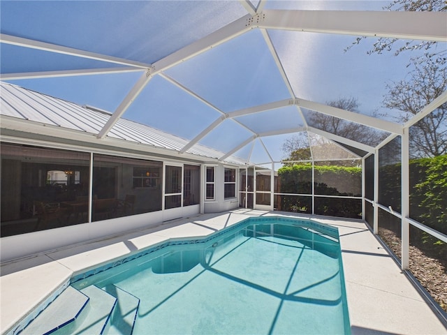 view of swimming pool featuring glass enclosure, a patio, and a fenced in pool