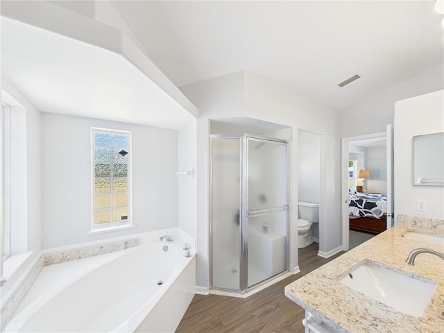 bathroom with visible vents, toilet, a stall shower, wood finished floors, and a sink