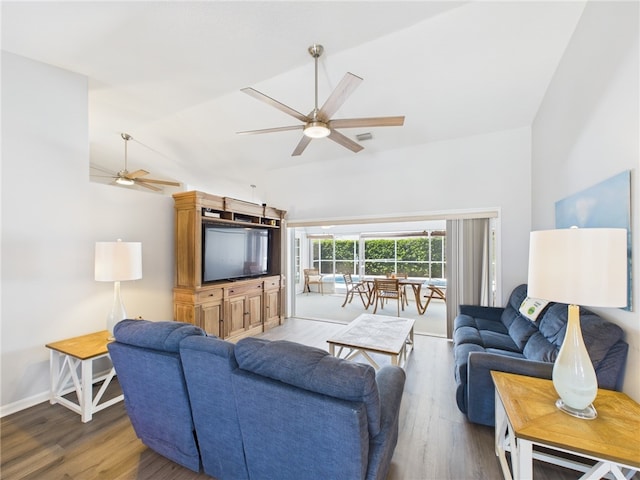 living room featuring visible vents, lofted ceiling, wood finished floors, and a ceiling fan