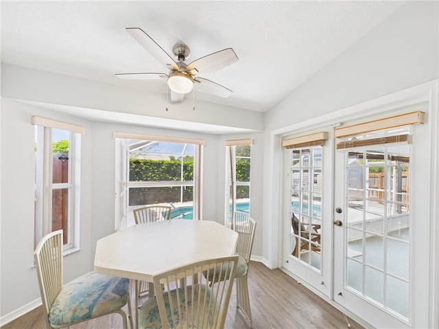 dining room featuring wood finished floors, french doors, baseboards, ceiling fan, and vaulted ceiling