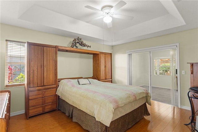 1359 Damask Ln, Sebastian, FL 32958 - bedroom featuring a tray ceiling, light wood finished floors, baseboards, and a ceiling fan