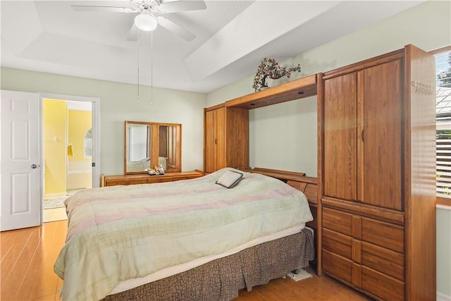 1359 Damask Ln, Sebastian, FL 32958 - bedroom with a tray ceiling, light wood finished floors, a ceiling fan, and connected bathroom
